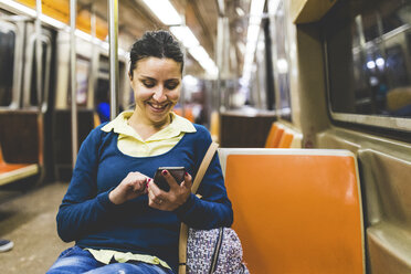 USA, New York, Frau benutzt Mobiltelefon in der U-Bahn - WPEF00047