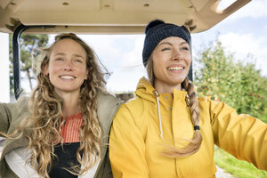 Zwei lächelnde Frauen auf einem Traktor - PESF00948