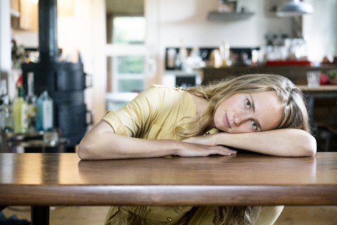 Porträt einer blonden Frau auf einem Tisch liegend, lizenzfreies Stockfoto