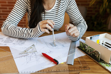 Junge Frau arbeitet in einem Architekturbüro und zeichnet Entwürfe - VABF01513