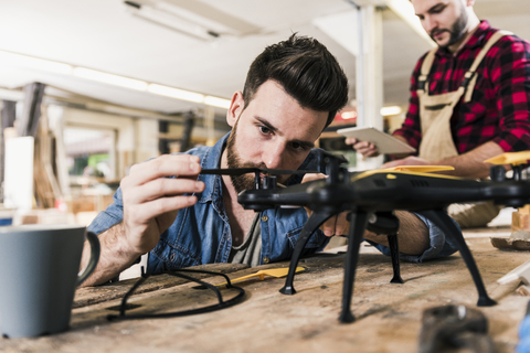 Mann arbeitet in der Werkstatt an einer Drohne, lizenzfreies Stockfoto