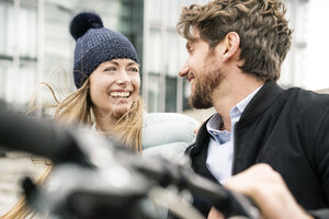 Glückliches Paar mit Fahrrad in der Stadt - PESF00994