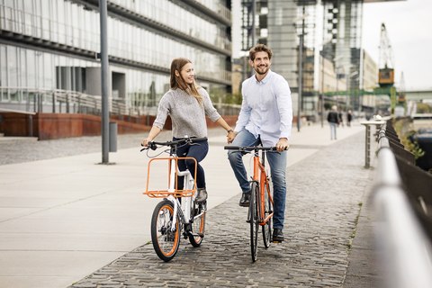 Lächelndes Paar beim Fahrradfahren in der Stadt, lizenzfreies Stockfoto