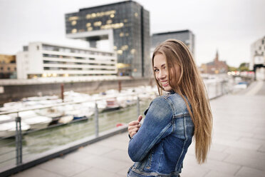 Portrait of happy young woman at city harbor - PESF01008