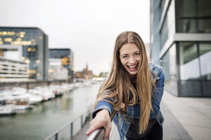 Porträt einer lachenden jungen Frau am Stadthafen - PESF01011
