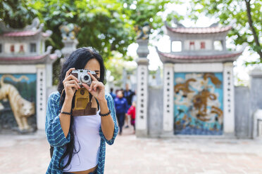 Vietnam, Hanoi, young woman taking a picture with old-fashioned camera - WPEF00049
