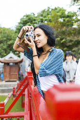 Vietnam, Hanoi, junge Frau beim Fotografieren mit altmodischer Kamera - WPEF00050