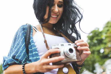 Lächelnde junge Frau mit einer altmodischen Kamera - WPEF00051