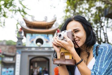 Vietnam, Hanoi, junge Frau beim Fotografieren mit altmodischer Kamera - WPEF00054