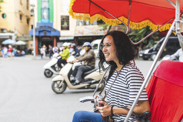 Vietnam, Hanoi, glückliche junge Frau auf einer Riksha bei der Erkundung der Stadt - WPEF00057