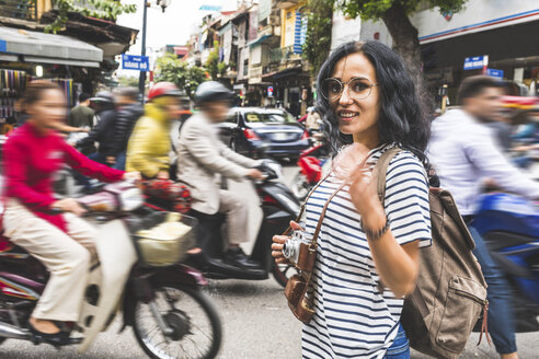 Vietnam, Hanoi, Porträt einer lächelnden jungen Frau inmitten des Verkehrs in der Stadt - WPEF00061