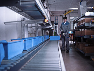 Worker scanning merchandise at conveyor belt - CVF00127