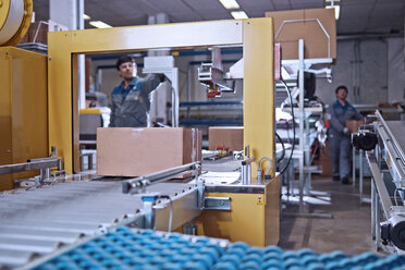 Männer bei der Arbeit am Fließband in einer Fabrik - CVF00128