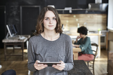 Porträt einer jungen Frau mit einem Tablet in einem modernen Büro - FMKF04795