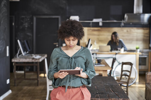 Junge Frau benutzt Tablet in einem modernen Büro - FMKF04799