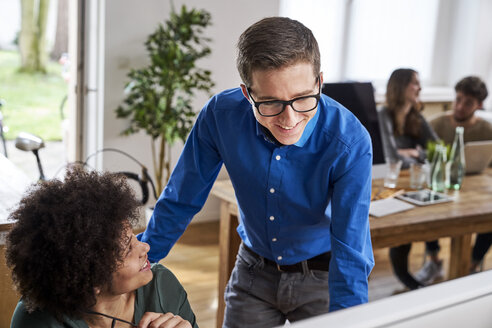 Lächelnde Arbeitskollegen im Büro - FMKF04822