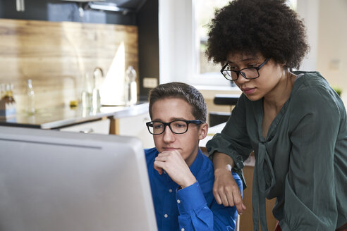 Zwei Kollegen schauen auf einen Computerbildschirm im Büro - FMKF04823