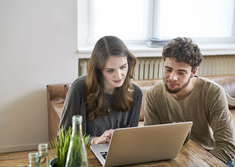 Zwei Kollegen arbeiten gemeinsam an einem Laptop - FMKF04824