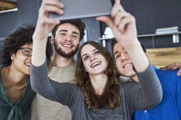 Smiling coworkers taking a selfie in office - FMKF04826