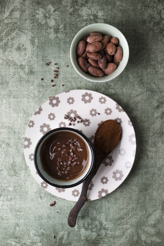 Tasse Schokoladenpudding mit Kakao, Kakaonibs und Kakaobohnen, lizenzfreies Stockfoto