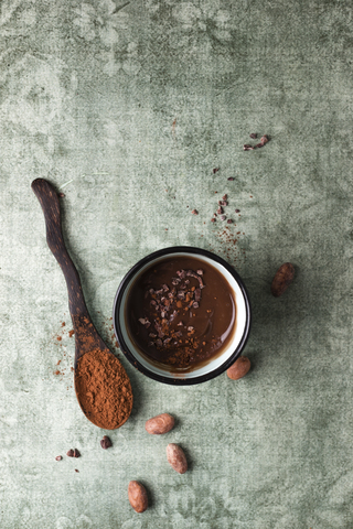 Tasse Schokoladenpudding mit Kakao, Kakaonibs und Kakaobohnen, lizenzfreies Stockfoto
