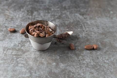 Becher Schokoladeneis mit Kakao und Kakaonibs bestreut, lizenzfreies Stockfoto