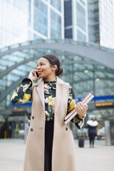 UK, London, portrait of smiling fashionable businesswoman on the phone - MAUF01314