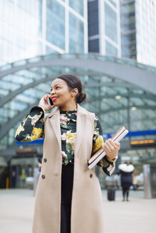 UK, London, Porträt einer lächelnden, modischen Geschäftsfrau beim Telefonieren - MAUF01314