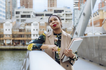 UK, London, portrait of fashionable businesswoman leaning on railing of bridge - MAUF01318