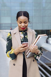 UK, London, fashionable businesswoman looking at cell phone - MAUF01319