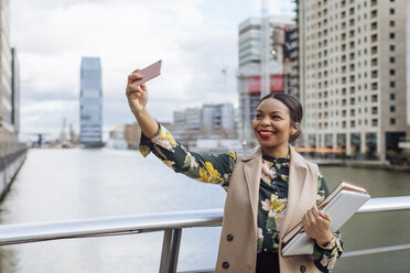 UK, London, portrait of fashionable businesswoman taking selfie with cell phone - MAUF01321