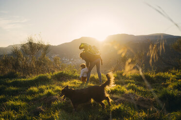 Spain, Barcelona, grandmother with granddaughter and dog during a hike at sunset - GEMF01876