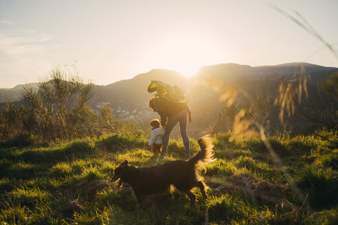 Spanien, Barcelona, Großmutter mit Enkelin und Hund bei einer Wanderung bei Sonnenuntergang - GEMF01876