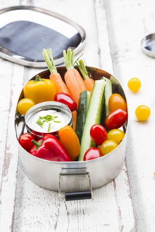 Lunchbox mit Dip aus Karotten, Paprika, Gurken, Tomaten und Schnittlauch, lizenzfreies Stockfoto