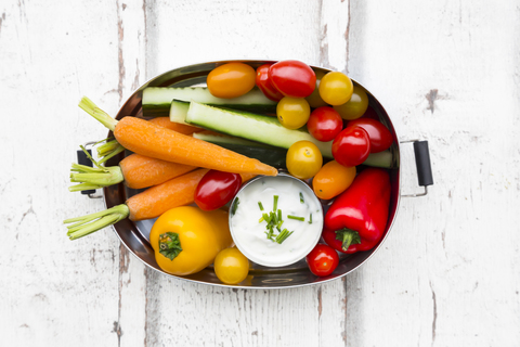 Lunchbox mit Dip aus Karotten, Paprika, Gurken, Tomaten und Schnittlauch, lizenzfreies Stockfoto