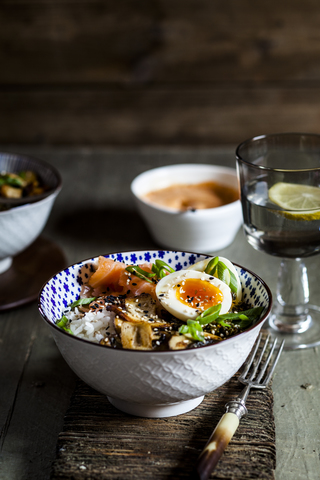 Lunch bowl, cooked egg, rice, smoked salmon, mushroom, green cabbage, sesame stock photo