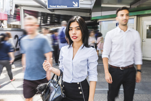Thailand, Bangkok, Porträt einer Geschäftsfrau inmitten sich bewegender Menschen in der Stadt - WPEF00081