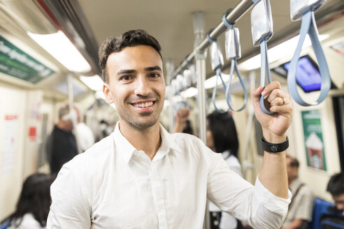 Porträt eines lächelnden Geschäftsmannes in der U-Bahn - WPEF00088