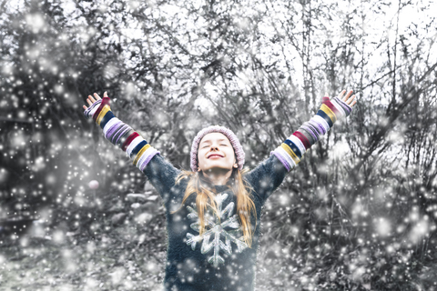 Happy girl at snowfall stock photo