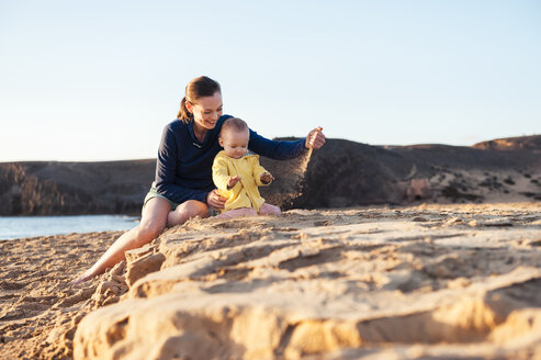 Mother playing with little daughter on the beach - DIGF03236