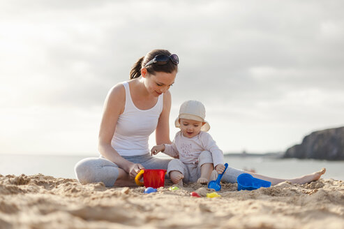 Mother playing with little daughter on the beach - DIGF03248