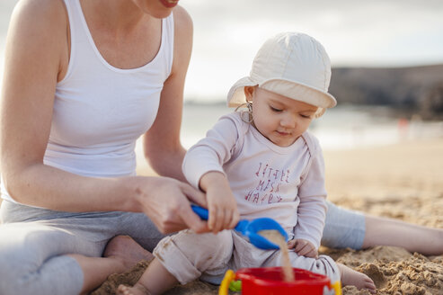 Mother playing with little daughter on the beach - DIGF03249