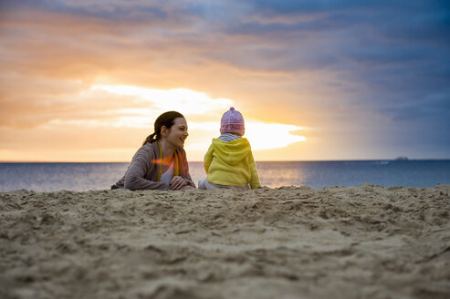 Mother with little daughter on the beach at sunset - DIGF03267