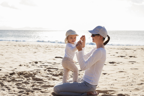 Happy mother with little daughter on the beach stock photo