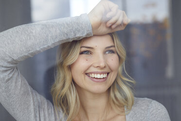 Portrait of happy woman looking out of window - PNEF00527