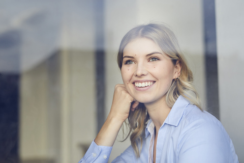 Portrait of content businesswoman looking out of window stock photo