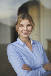 Portrait of content businesswoman behind windowpane - PNEF00534