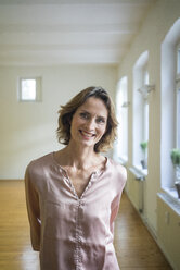 Portrait of smiling mature woman in empty room - MOEF00747