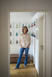 Portrait of smiling mature woman standing in a room with keyrings - MOEF00792