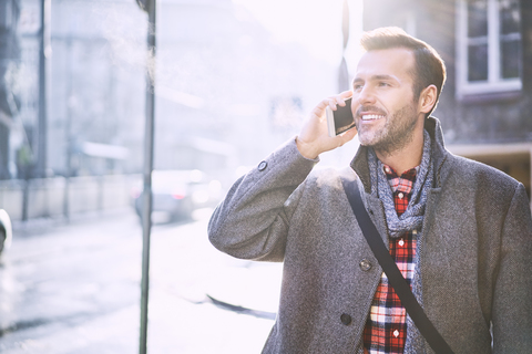 Portrait of smiling man on the phone in winter stock photo
